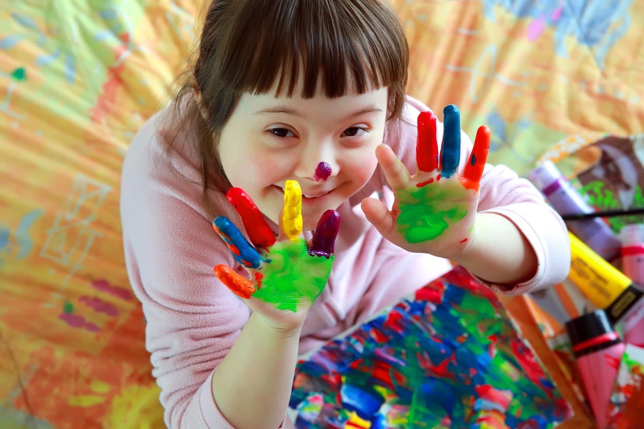 This photo if from Gigi's Playhouse. It is a girl playing with paint. This is a photo advertisement for Art Explosion Class.